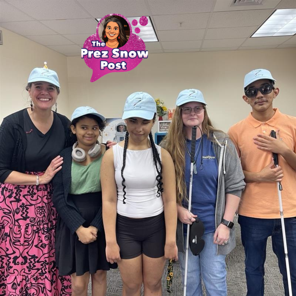 Tracie Snow wearing matching  blue ball caps with group of blind students who stopped in her office for a photo.