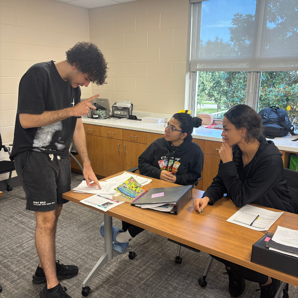 Three SOAR students giving each other feedback inside the classroom. 