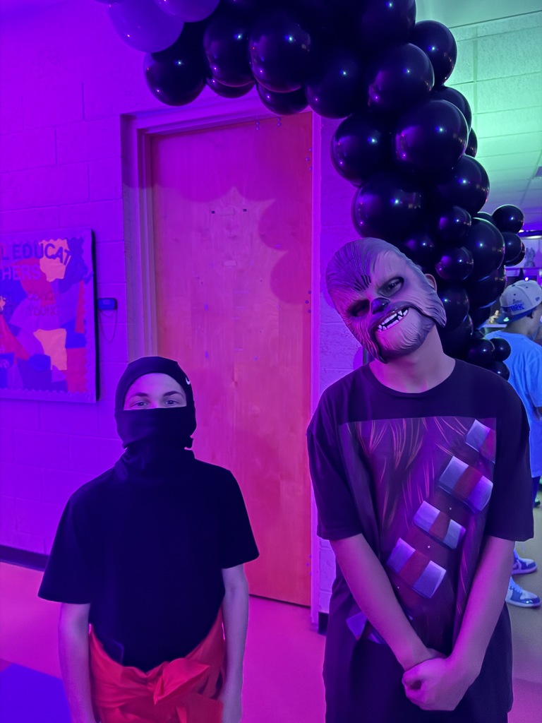 Two students are dressed up for Halloween pose for a photo together inside the dorm. 