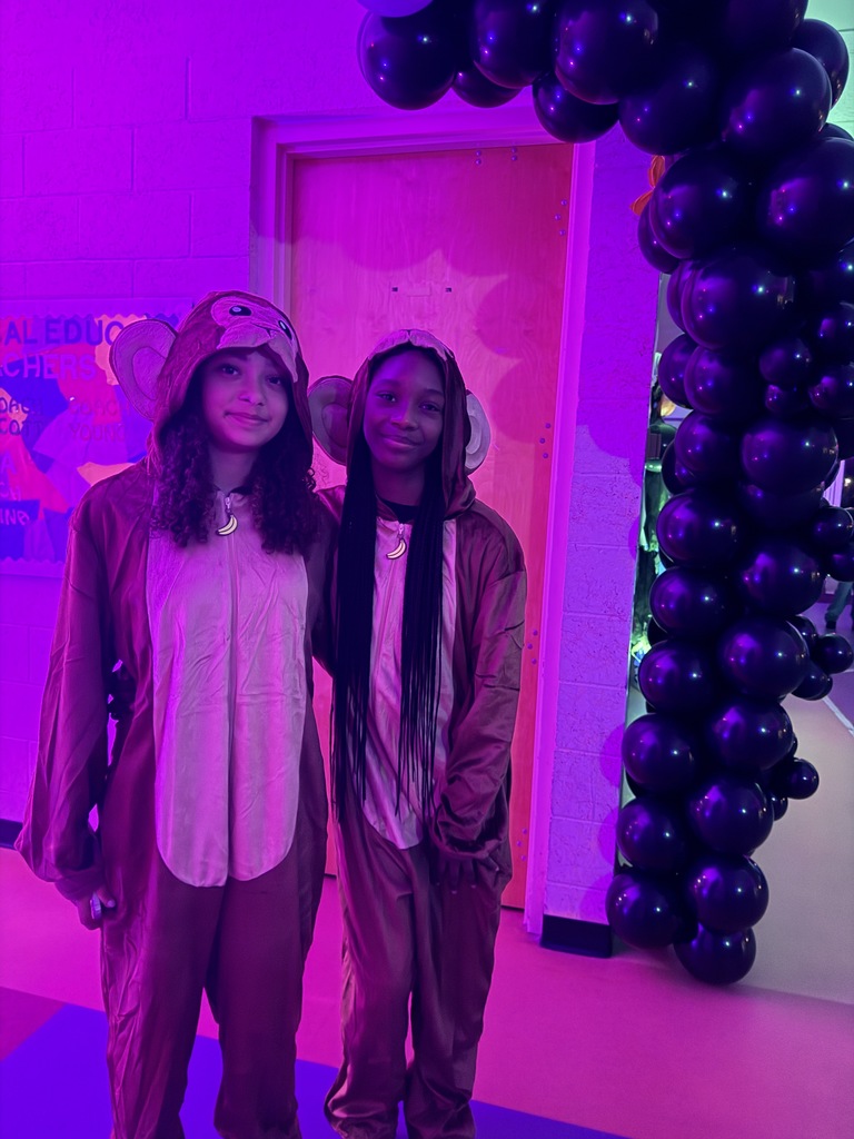Two students are dressed up like monkeys for halloween smile together for a photo inside the dorm. 