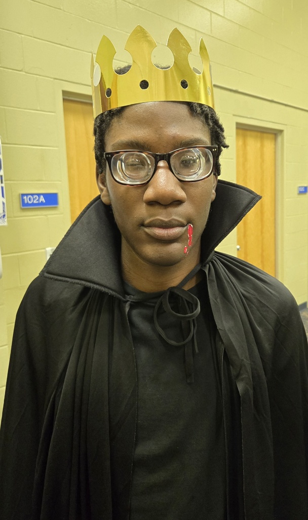 A student is dressed like a vampire with a fake red spot on his mouth. 