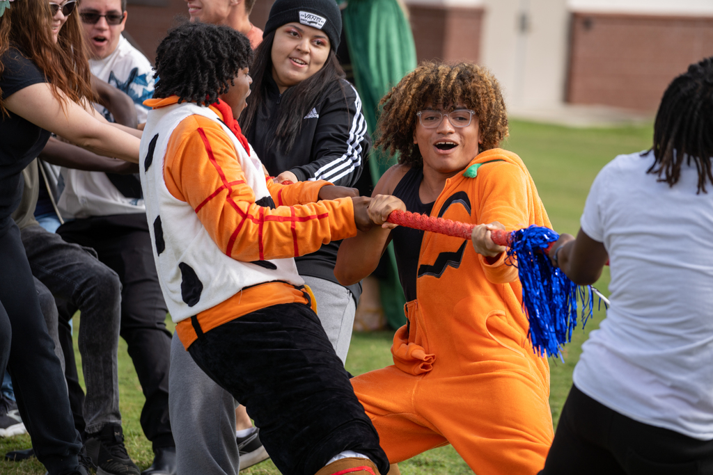 Two students is dressed up pulling on the ropes during the rug of war challenge. 