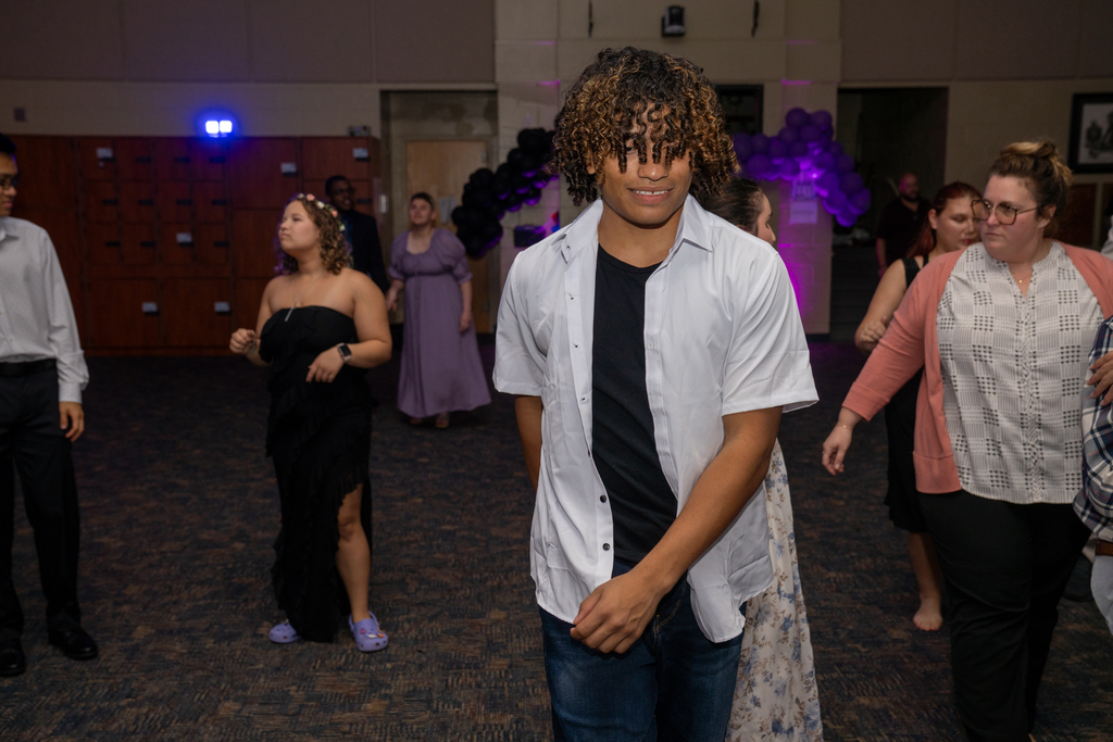 A student is smiling and dancing on the dance floor in the music building. 