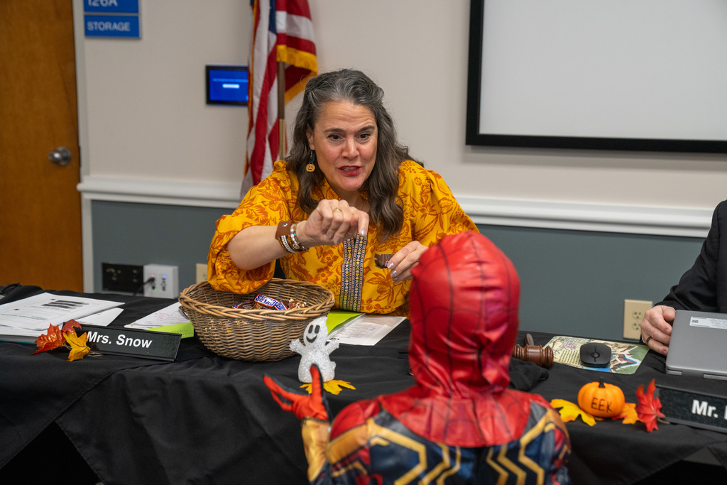 FSDB President sign to a ELC student as he reaches for candy during Board of Trustee meeting. 
