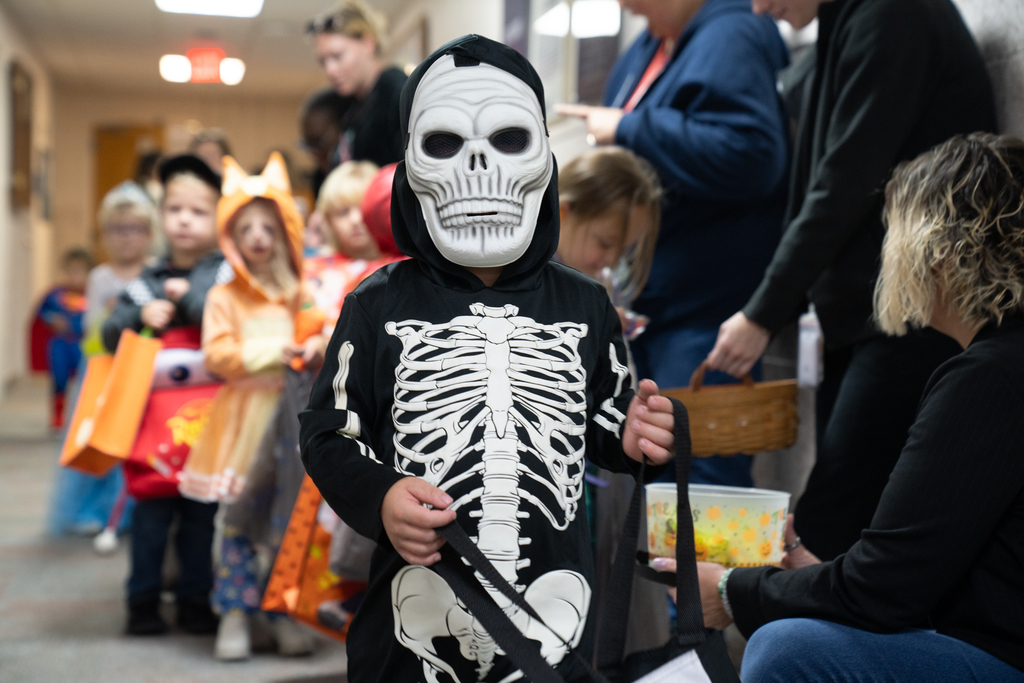 A student dressed like a Skelton walking through the hallway of Moore Hall. 