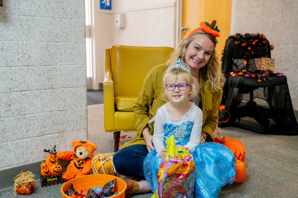 A staff member smile with a ELC student dressed like Elsa. 
