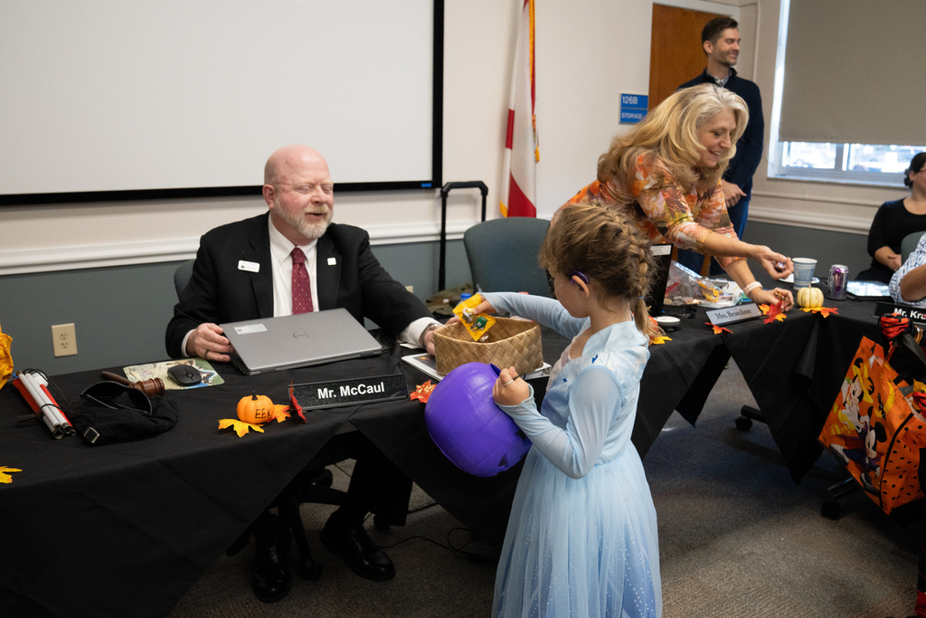 Board of Trustee member hands an ELC student some candy. 