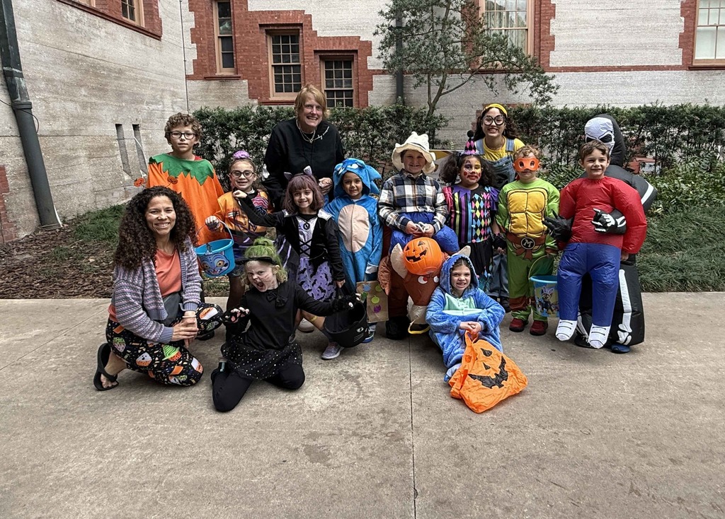 Group of dorm staff dressed up for Halloween along with the students smiling for a photo outside of Flagler College,.
