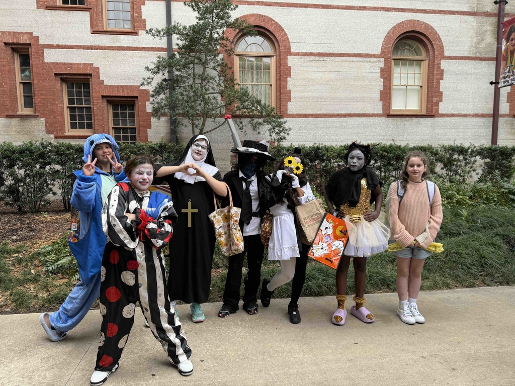 Group of dorm staff dressed up for Halloween along with the students smiling for a photo outside of Flagler College,.
