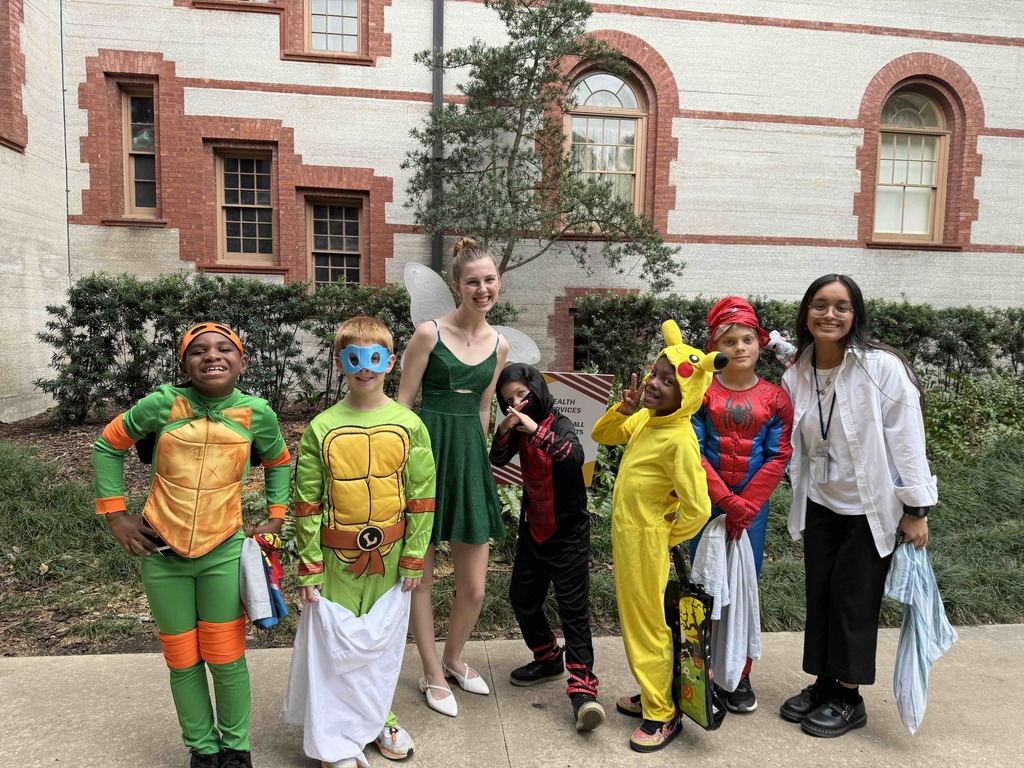 Group of dorm staff dressed up for Halloween along with the students smiling for a photo outside of Flagler College,.