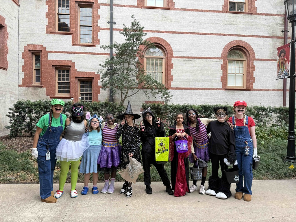 Group of dorm staff dressed up for Halloween along with the students smiling for a photo outside of Flagler College,.