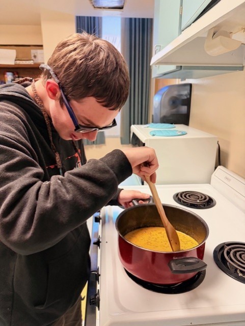 Aubrey is cooking hamburger helper meal in the kitchen. 