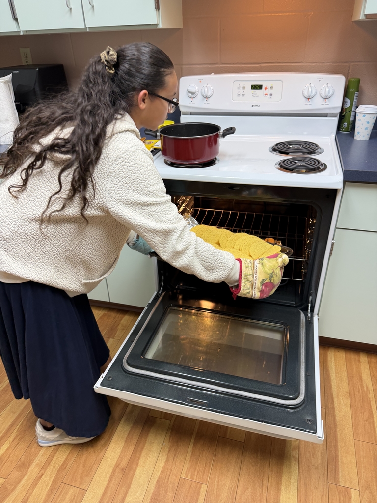 A student is putting the hard shells in the oven inside the Cary White kitchen. 