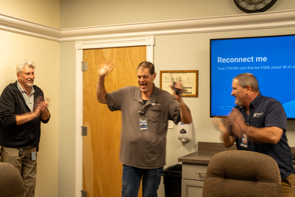 Last picture is of Joe walking into the Hogle Conference room being surprised by his peers and family.  His arms are up in the air and he has a big surprised look on his face.  Ray Casson and Guy Maltese are on both sides of Joe clapping.