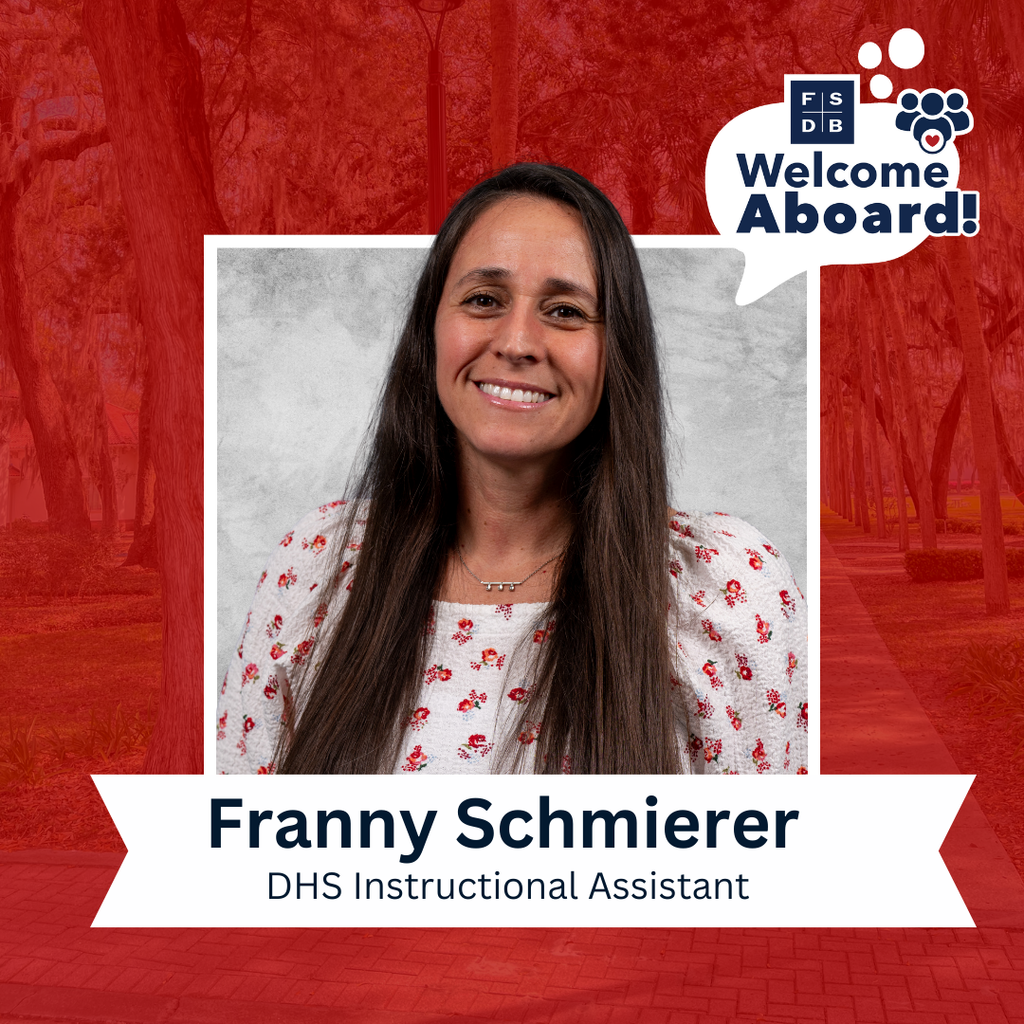 Franny is wearing a white with red flowers scattered over shirt with a silver back drop and red background. Below her photo is a white text box that says "Franny Schmierer, DHS Instructional Assistant"