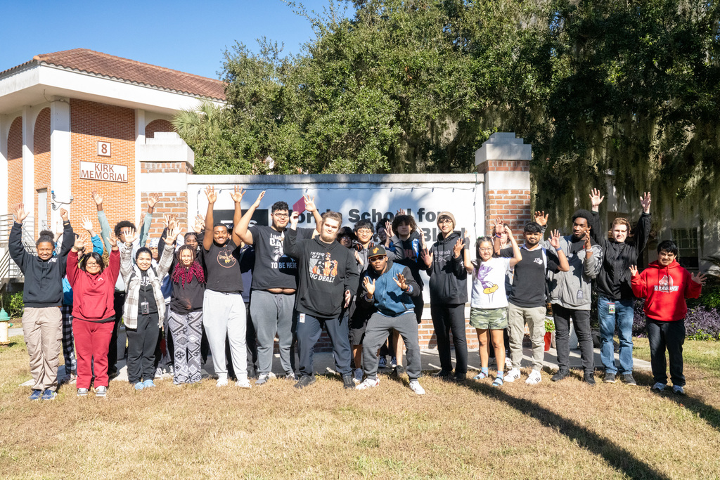Shane in the middle with his SOAR classmates surrounding him cheering by the FSDB sign. 
