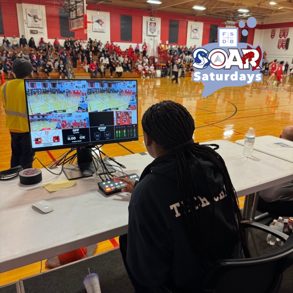 A SOAR student worker is working on the livestream for Clerc Classic inside Settles Gym.