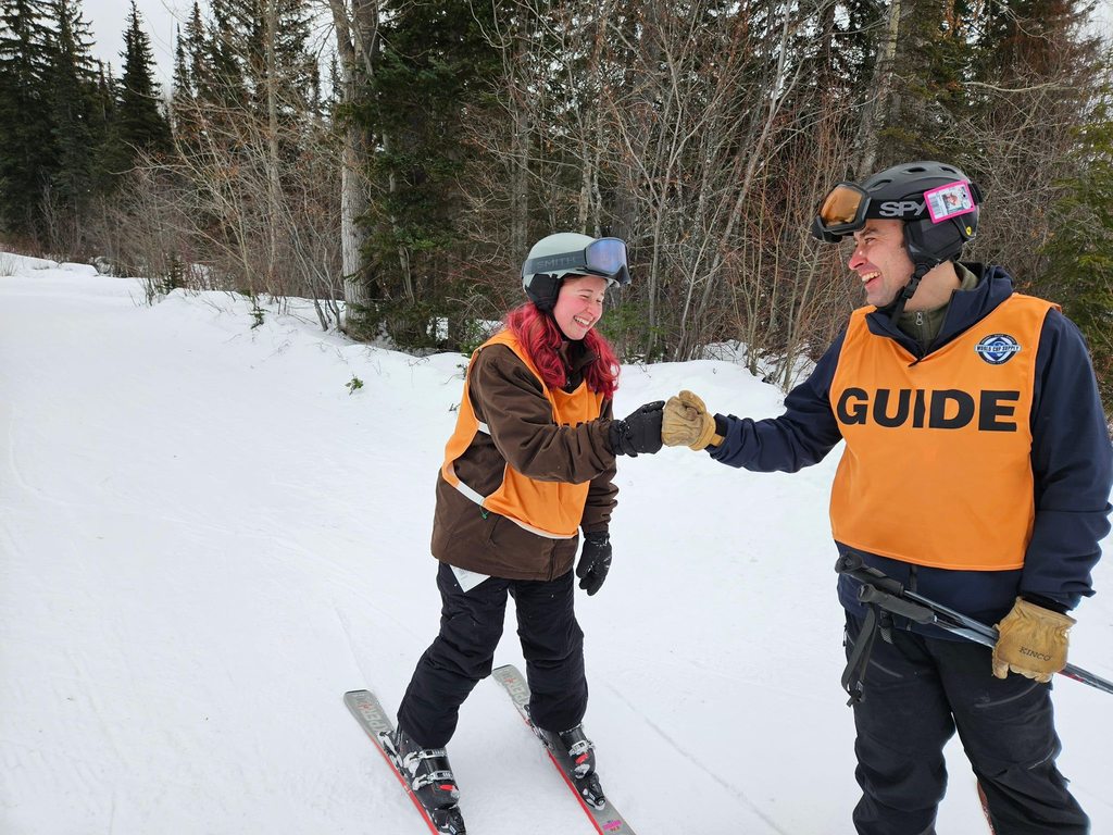 A blind student fist bump her guide on the slopes. 