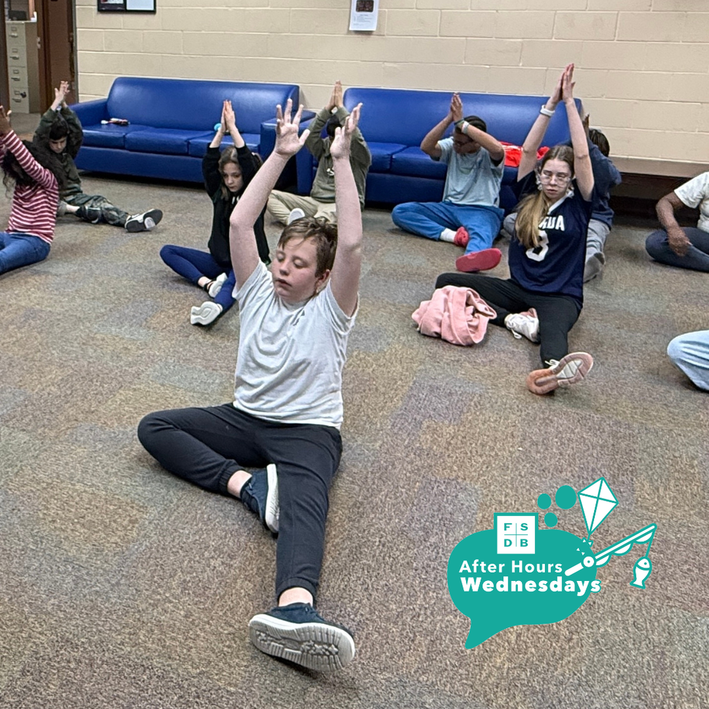 Blind students doing Yoga in the hallway of Cary White. 