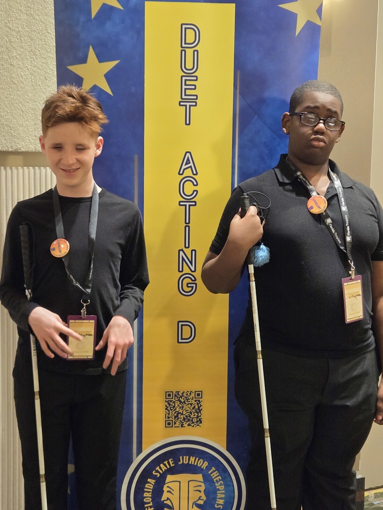 JJ and Amari in front of the sign to their competition room. They are wearing their Excellent buttons
