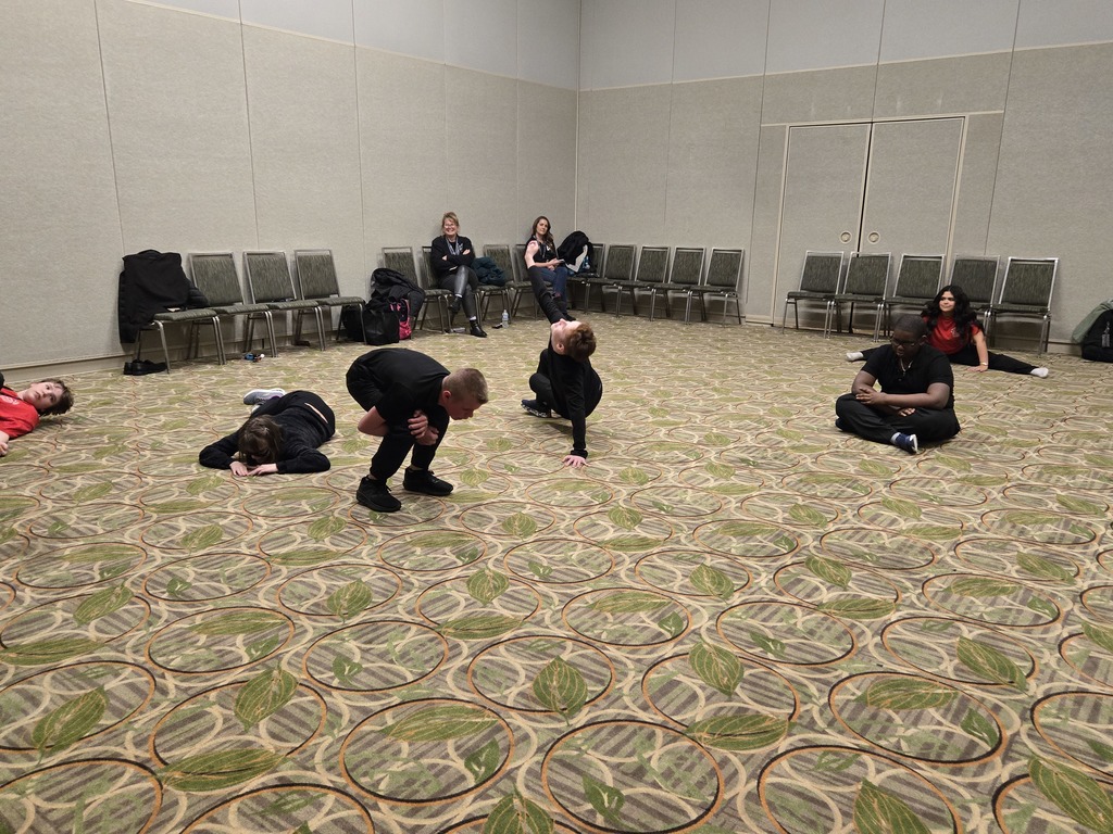 In a workshop, the students are making a shape with their bodies