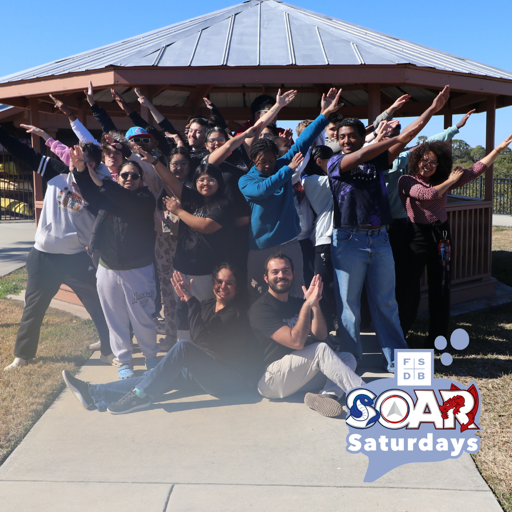 Group of SOAR students signing the SOAR sign outside FSDB pavilion by the water.