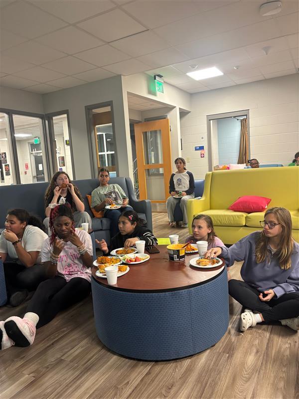 Girl dorm students eat while watching the Super Bowl.