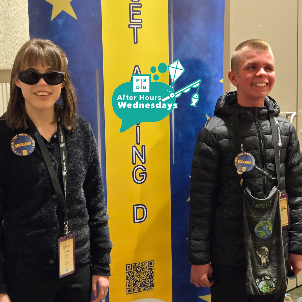 Arabella and Whyatt beside the Duet Acting banner showing off their Superior Button