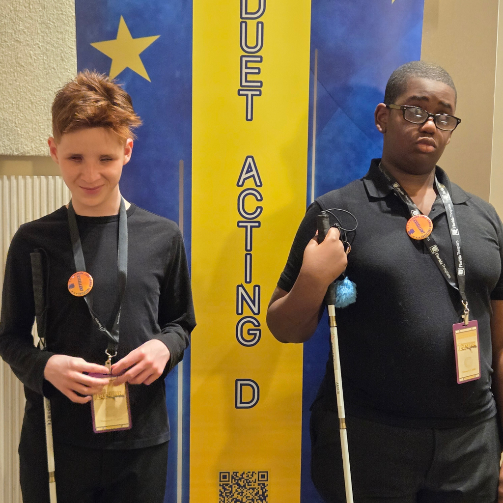 JJ and Amari beside the Duet Acting banner showing off their Excellent Button