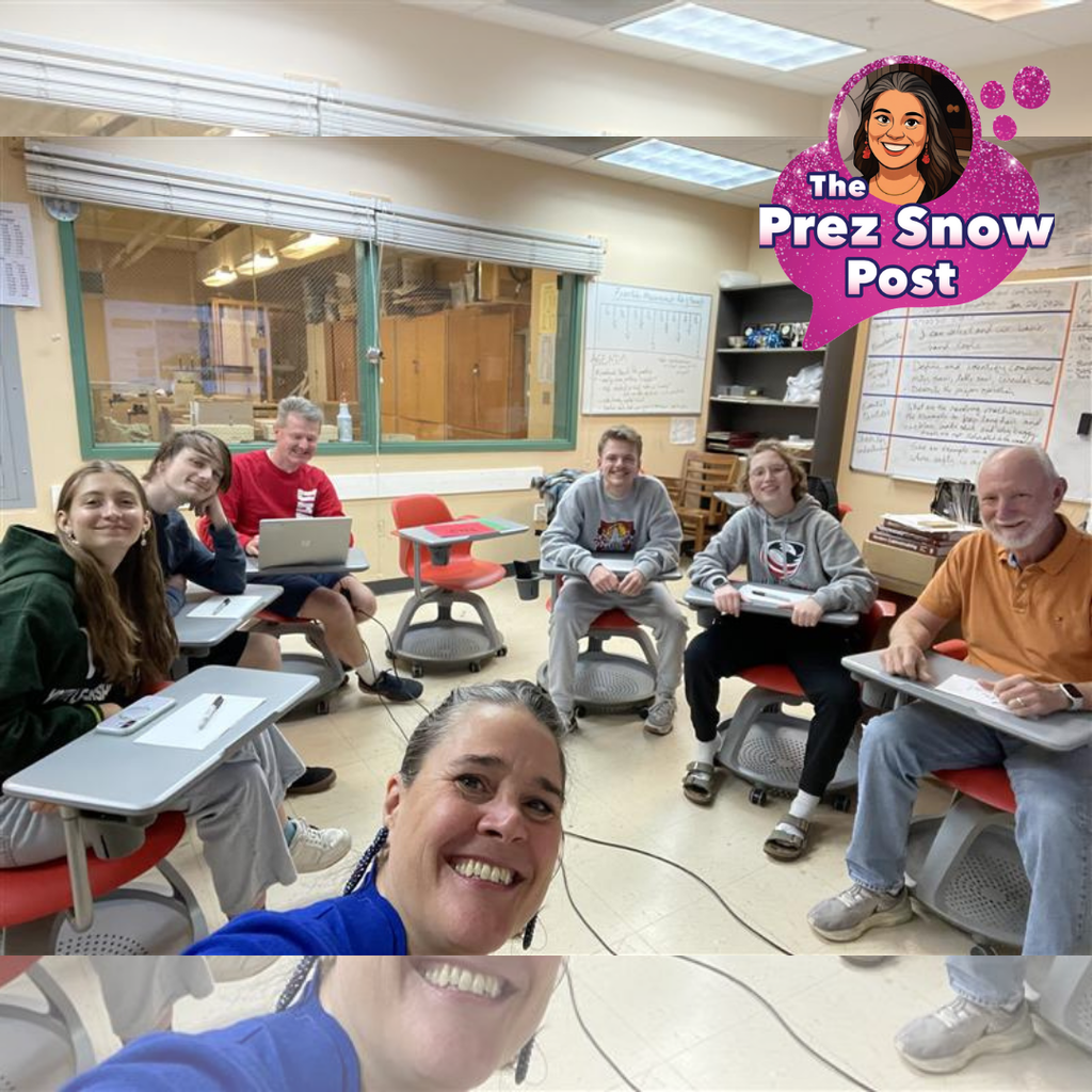 A selfie taken from the bottom of the frame shows President Snow capturing an FSDB Academic Bowl practice session. Students sit in a circle on red swivel desks, focused and engaged as they prepare for this weekend's competition.