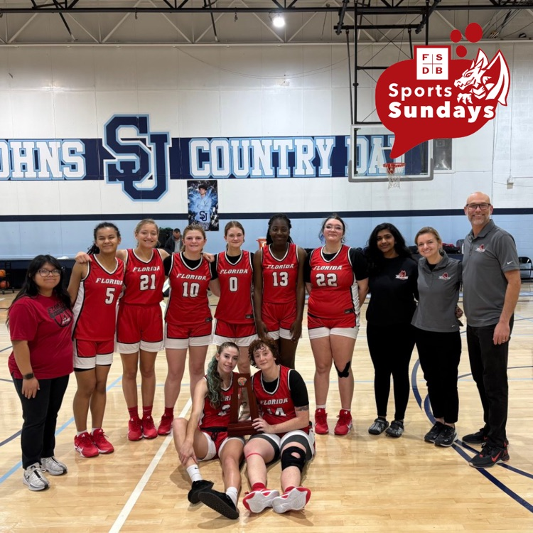 FSDB varsity basketball girls smile with their trophy inside the gym. 