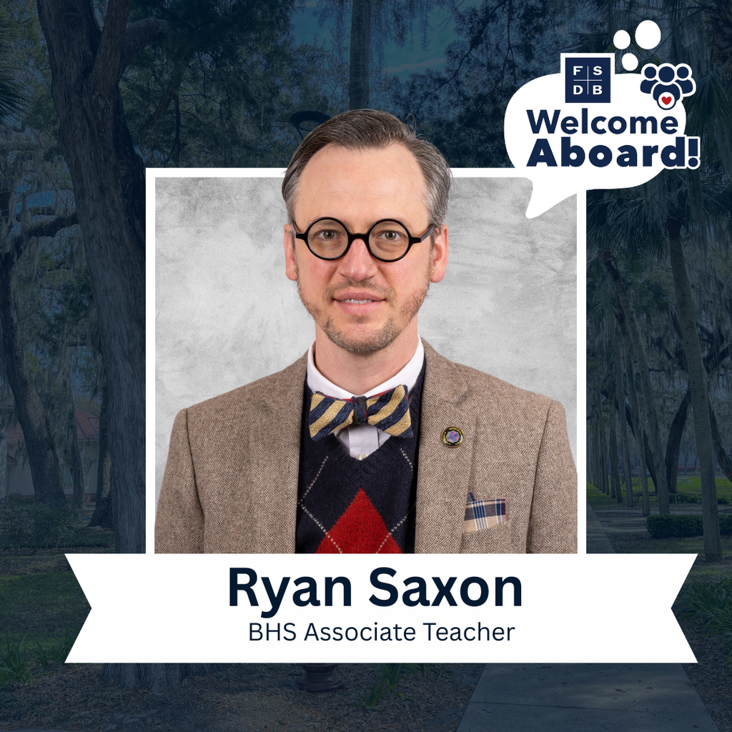 Ryan is wearing a tan color suit with a blue and gold bow tie smiles for his photo with a silver back drop and blue background. Below the photo says "Ryan Saxon, BHS Associate Teacher"