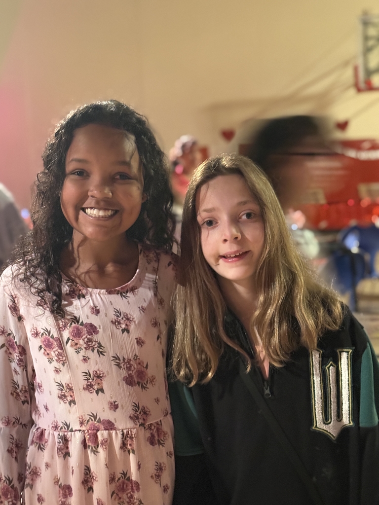 Two students smile for a photo together inside the gym.