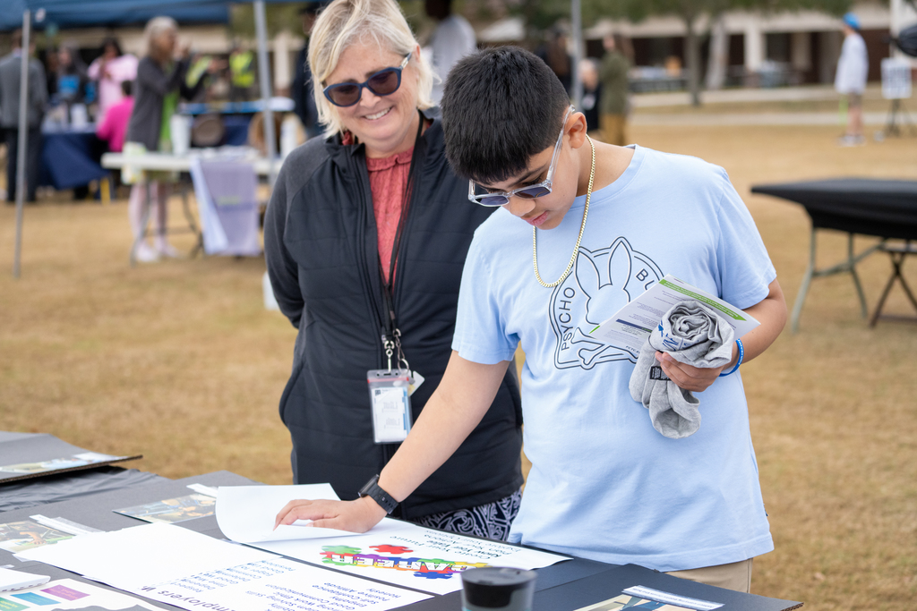 A student and staff member looking at an CTE Showcase table.