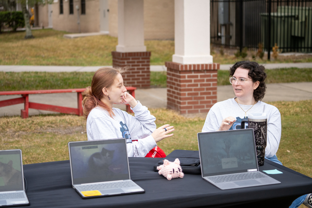 A staff member and student talking to each other at table.