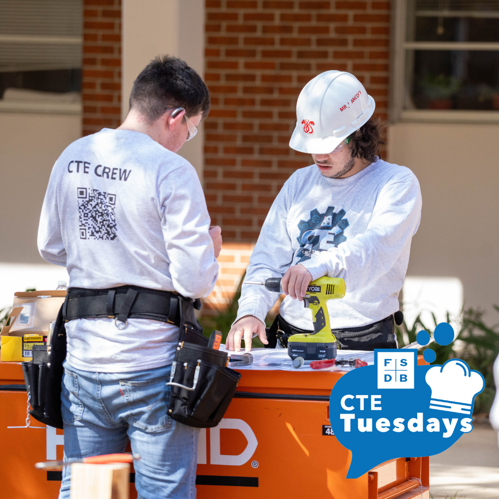 Two students working on construction outside.