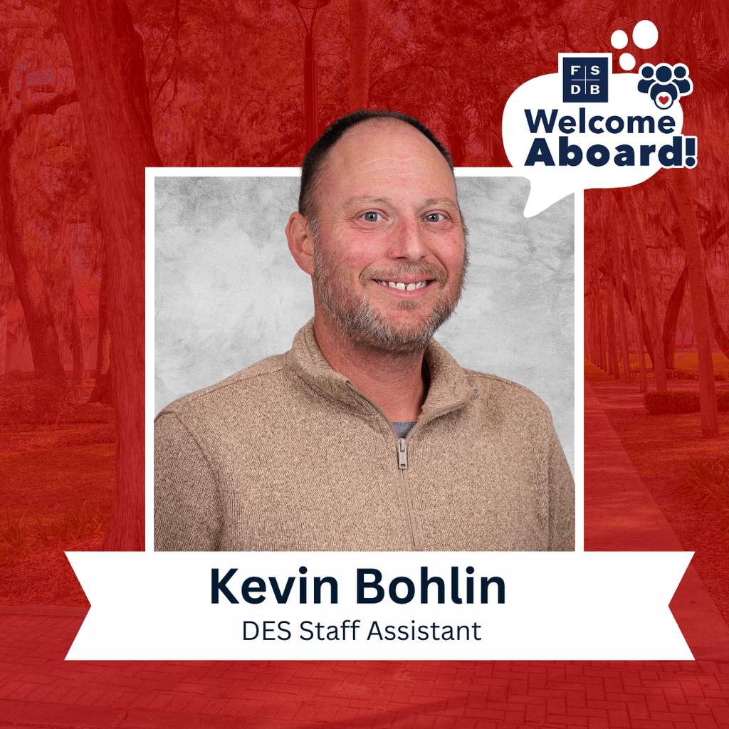 Kevin is wearing a tan color sweatshirt smiling for his photo with a silver backdrop and rd background. Below the photo is a white textbox that says "Kevin Bohlin, DES Staff Assistant"
