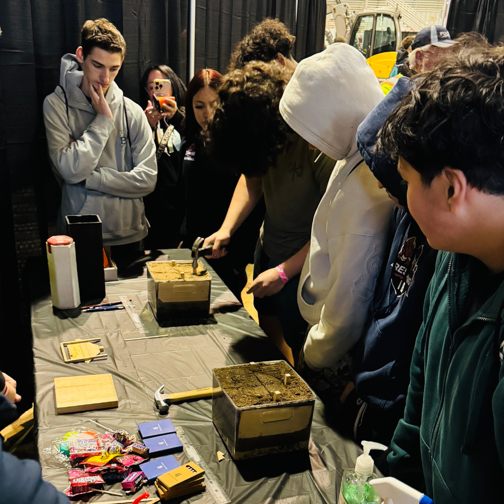 FSDB students hammering and looking at exhibits inside the building. 
