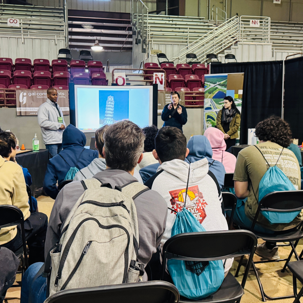 FSDB students sit in chairs and watch the presentation held by the organization inside the building. 