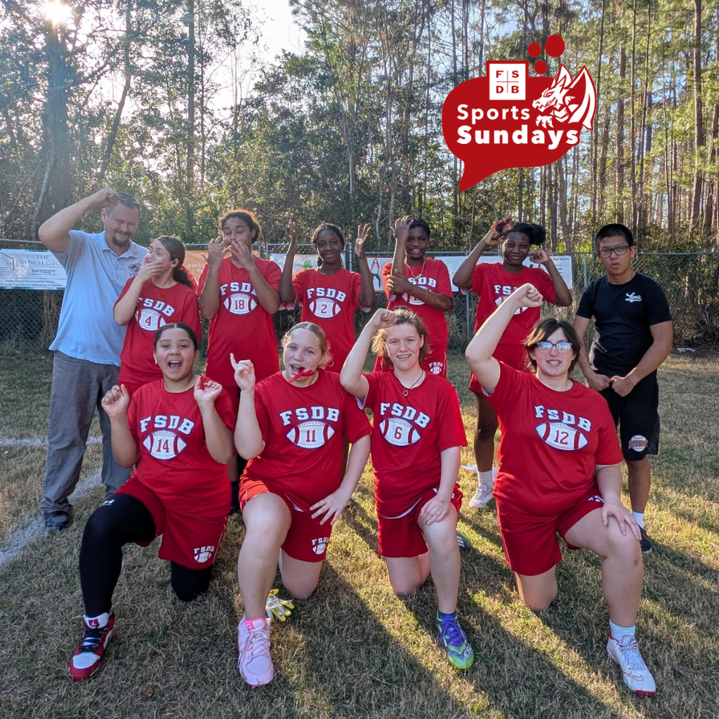 FSDB Girls Middle School Flag Football team are wearing red uniforms and posing for the photo outside. 