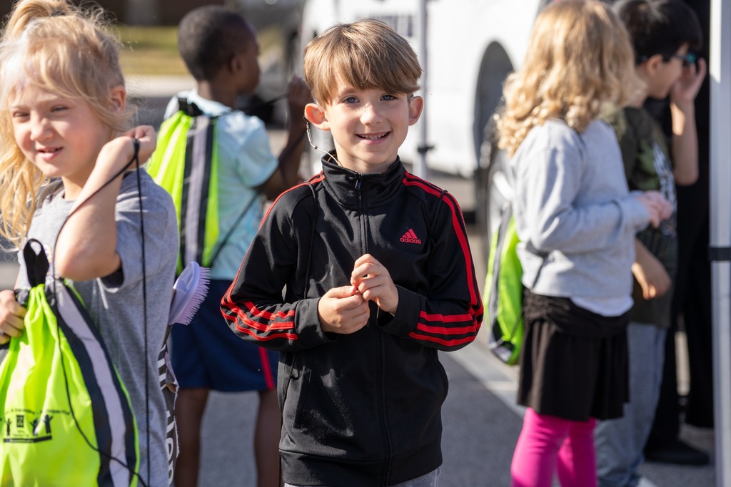 A student walking and smiles for a photo. 