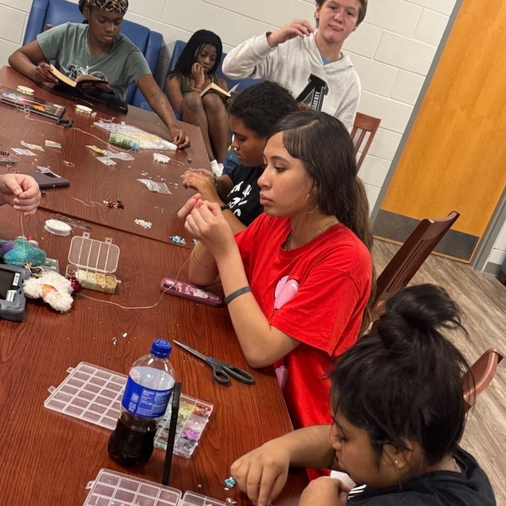 Students work on crafts at the table inside the dorms.