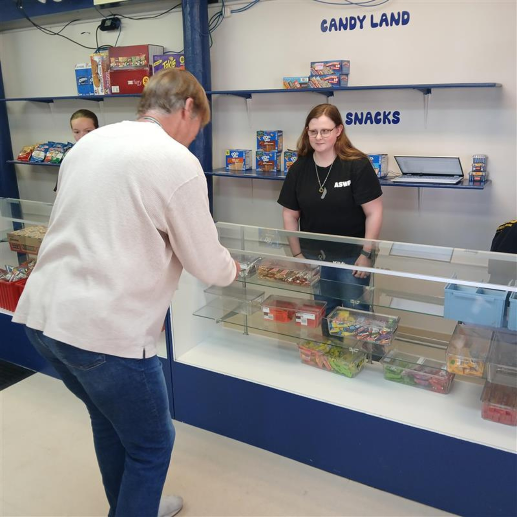 A closeup shot of a customer making his purchase with a student worker.