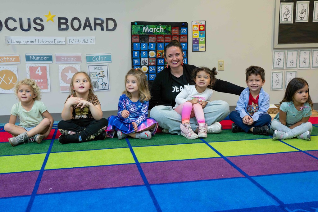 Group of ELC students smile with Dr. Renca inside the ELC classroom.