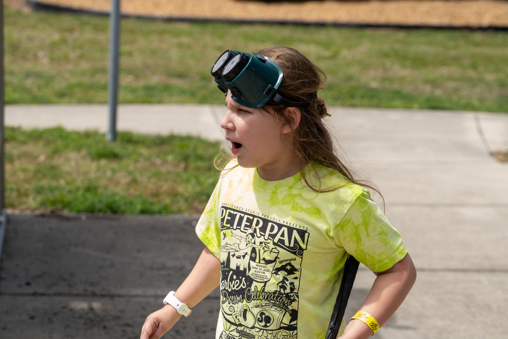 A student has her eye mask on her head as she looks in the distance outside.