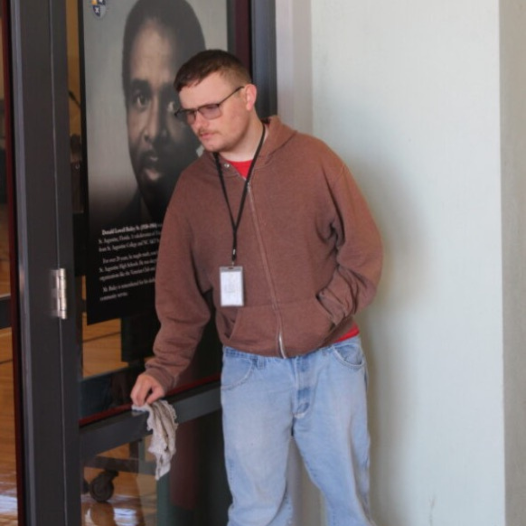 Allan is cleaning the doors of a store.