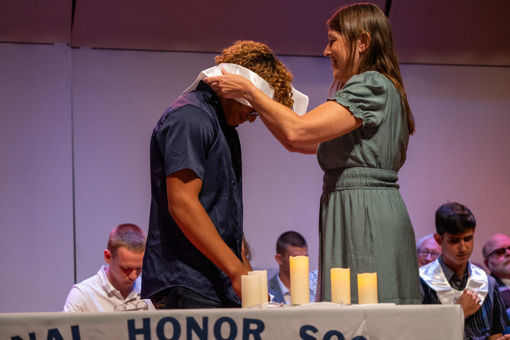 Addison receives his NHS sash on stage in the music building.