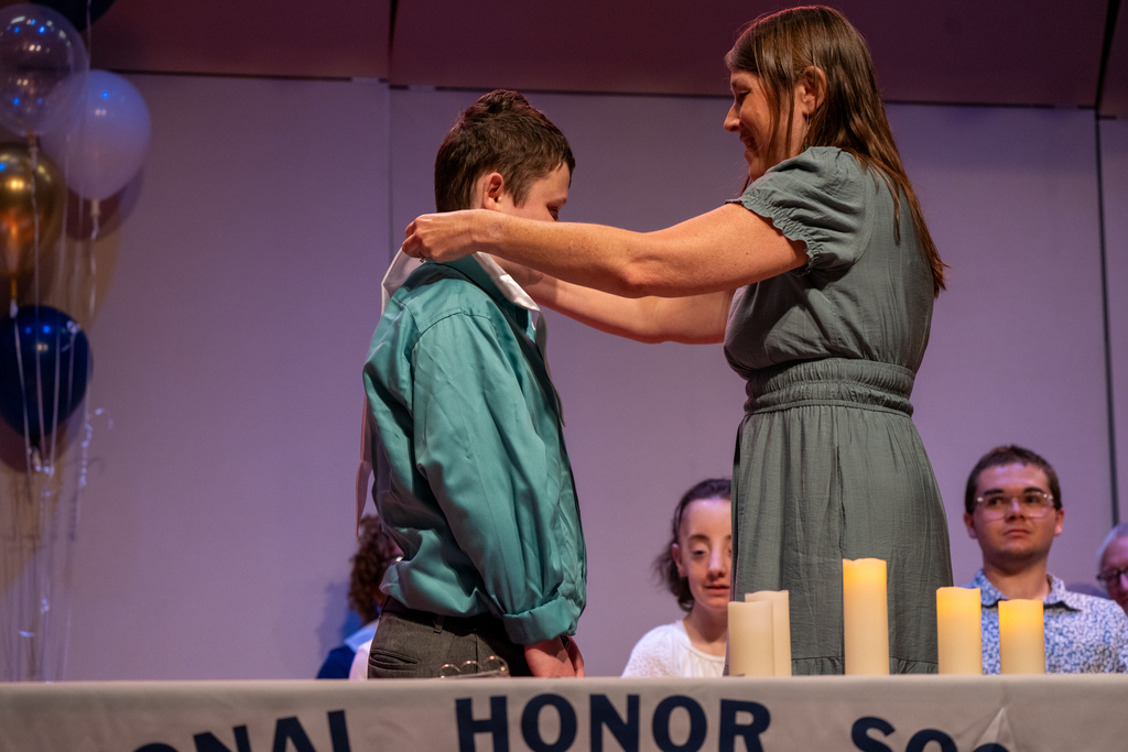 Logan receives his NHS sash on stage in the music building.