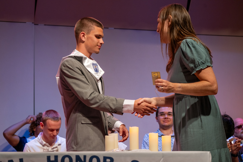 Jasen receives his NHS sash on stage in the music building.
