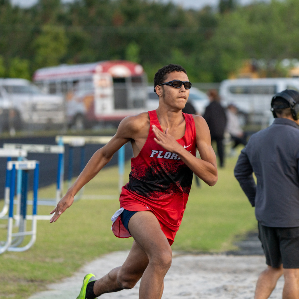 A FSDB boy runner runs to the finish line outside on the track field. 